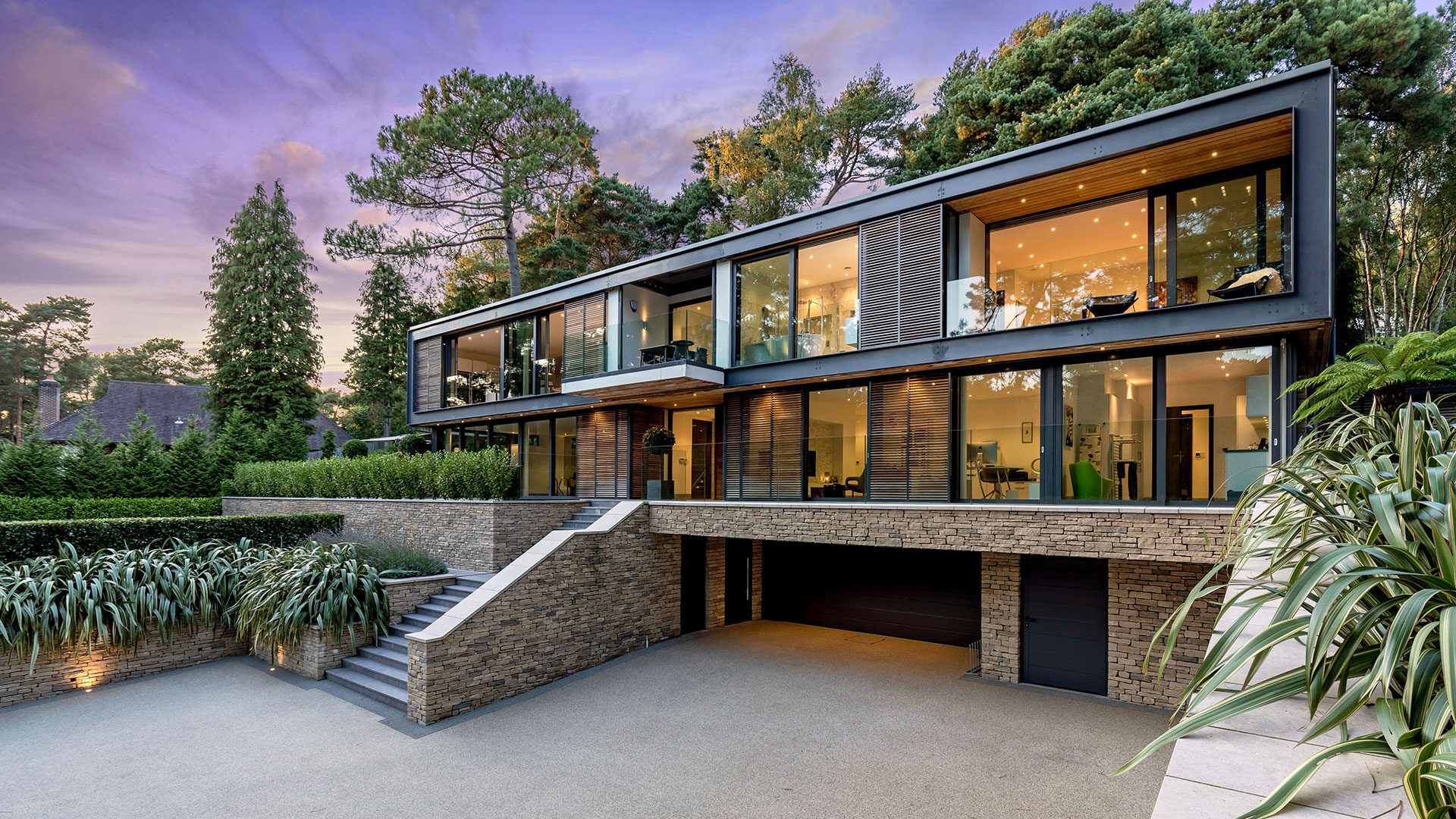 Contemporary house surrounded by trees at dusk