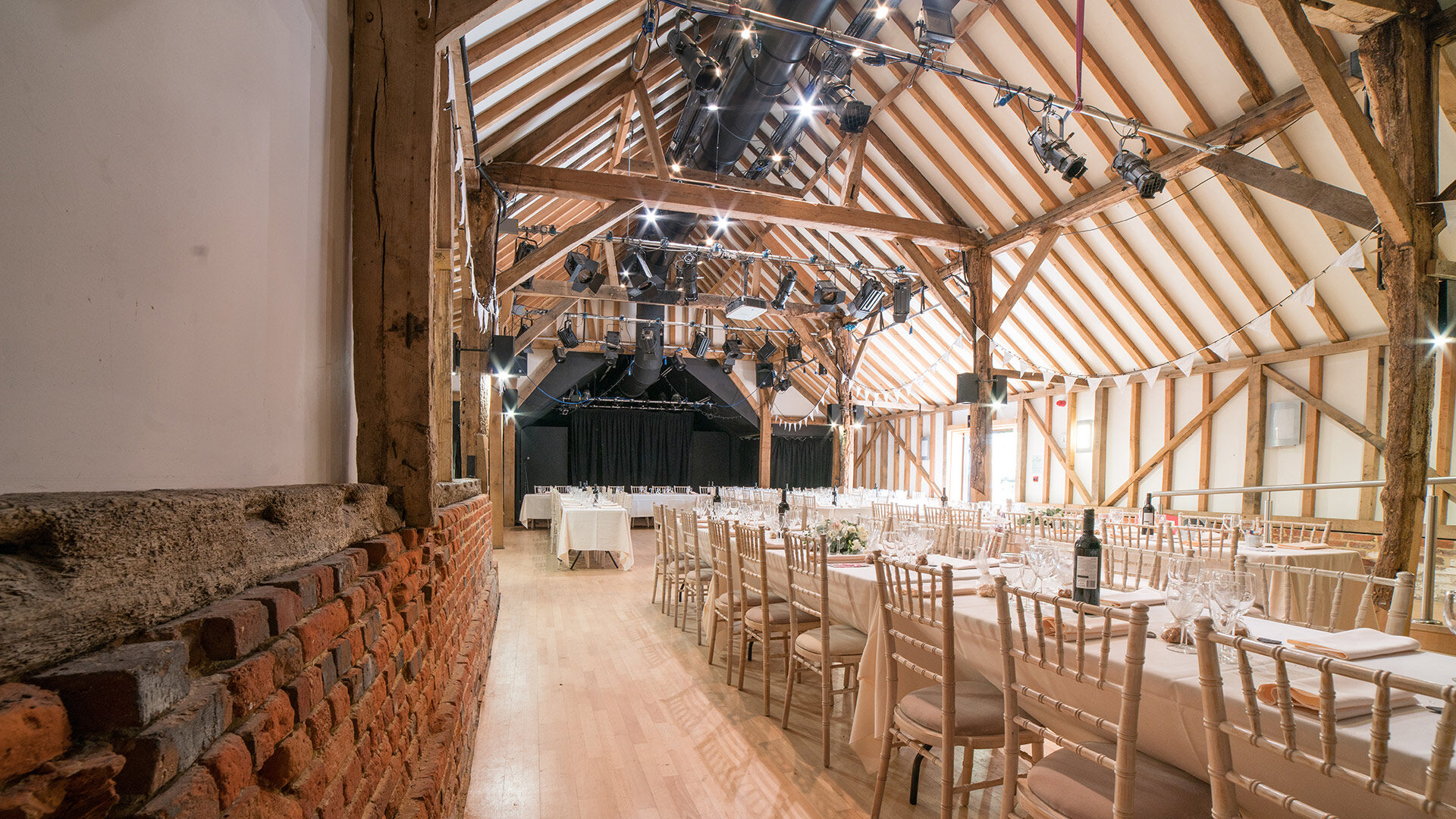 interior of converted barn with exposed beams and large open floor space