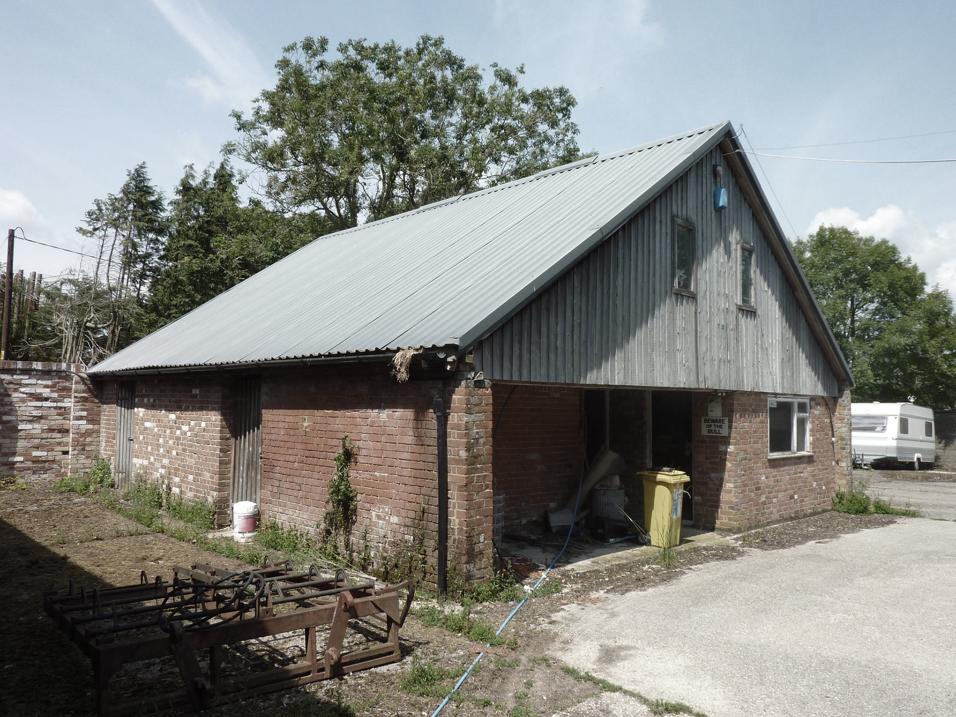 before photo of brick barn with corrugated roof