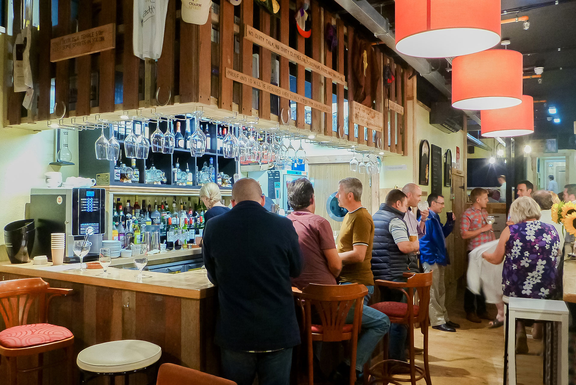 interior of wine bar with people stood around the bar