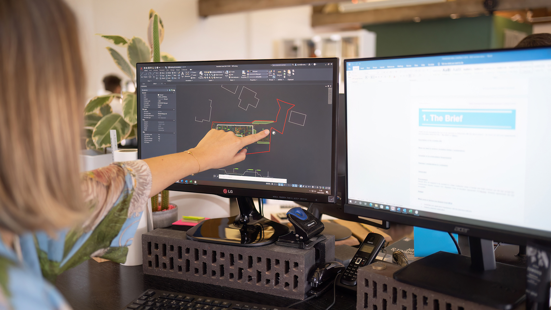 woman pointing at drawing on computer screen