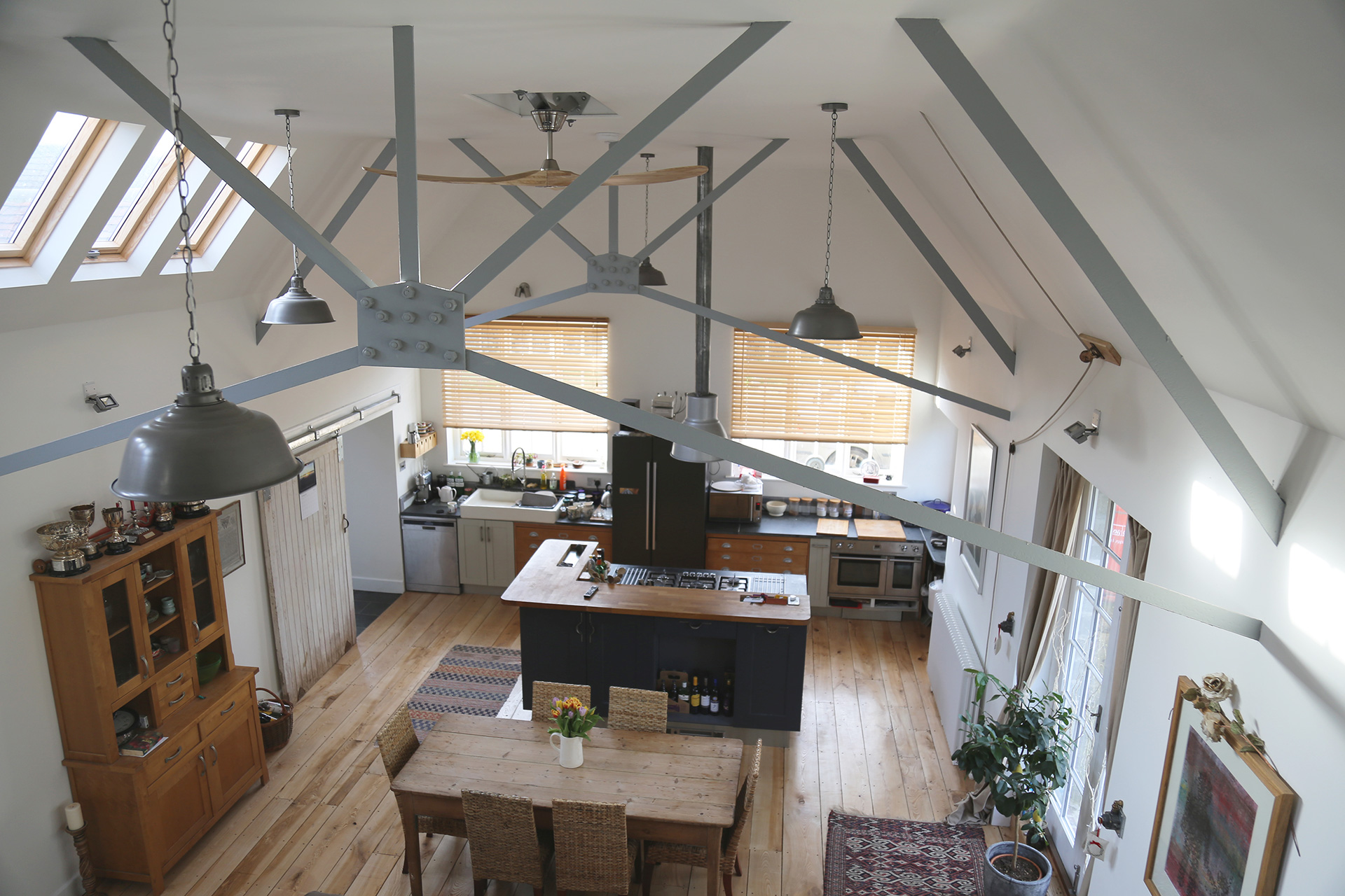 aerial internal view from mezzanine level of large kitchen and dining space with exposed beams