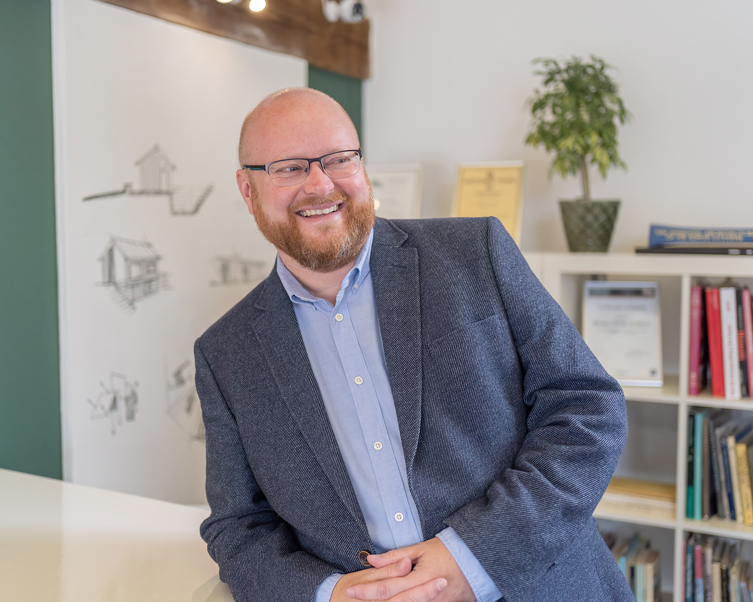 Jon Turvey smiling and leaning on table