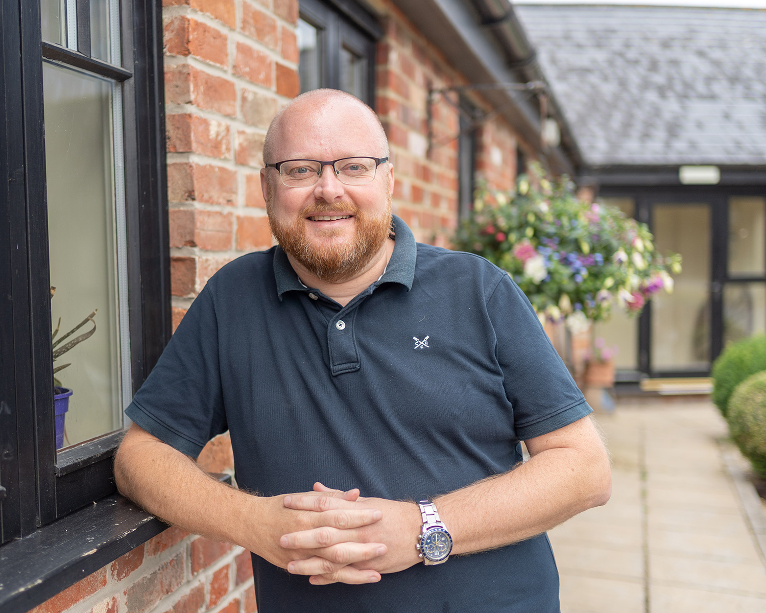 Jonathan Turvey RIBA smiling and leaning on window