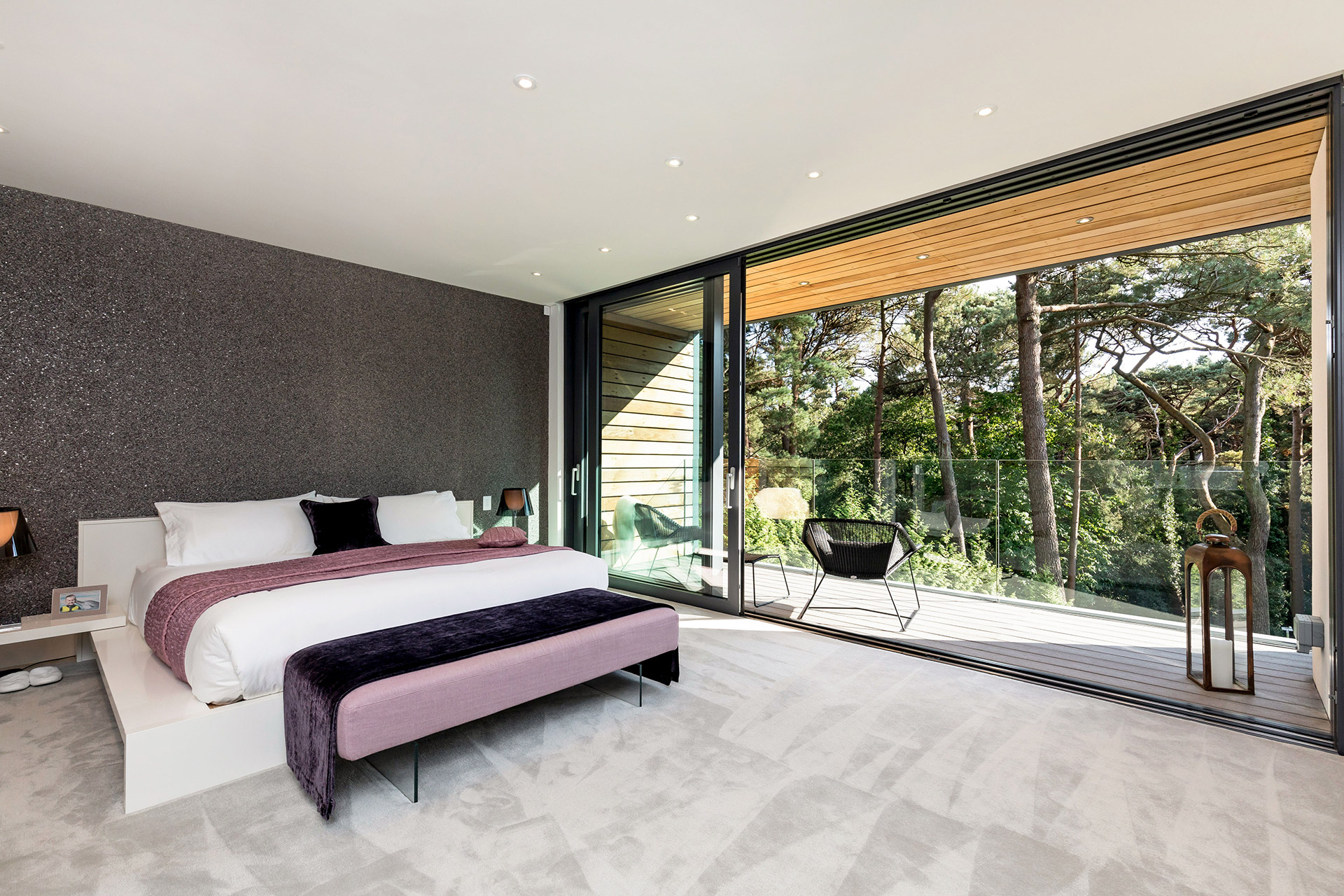 Bedroom with balcony and tree views