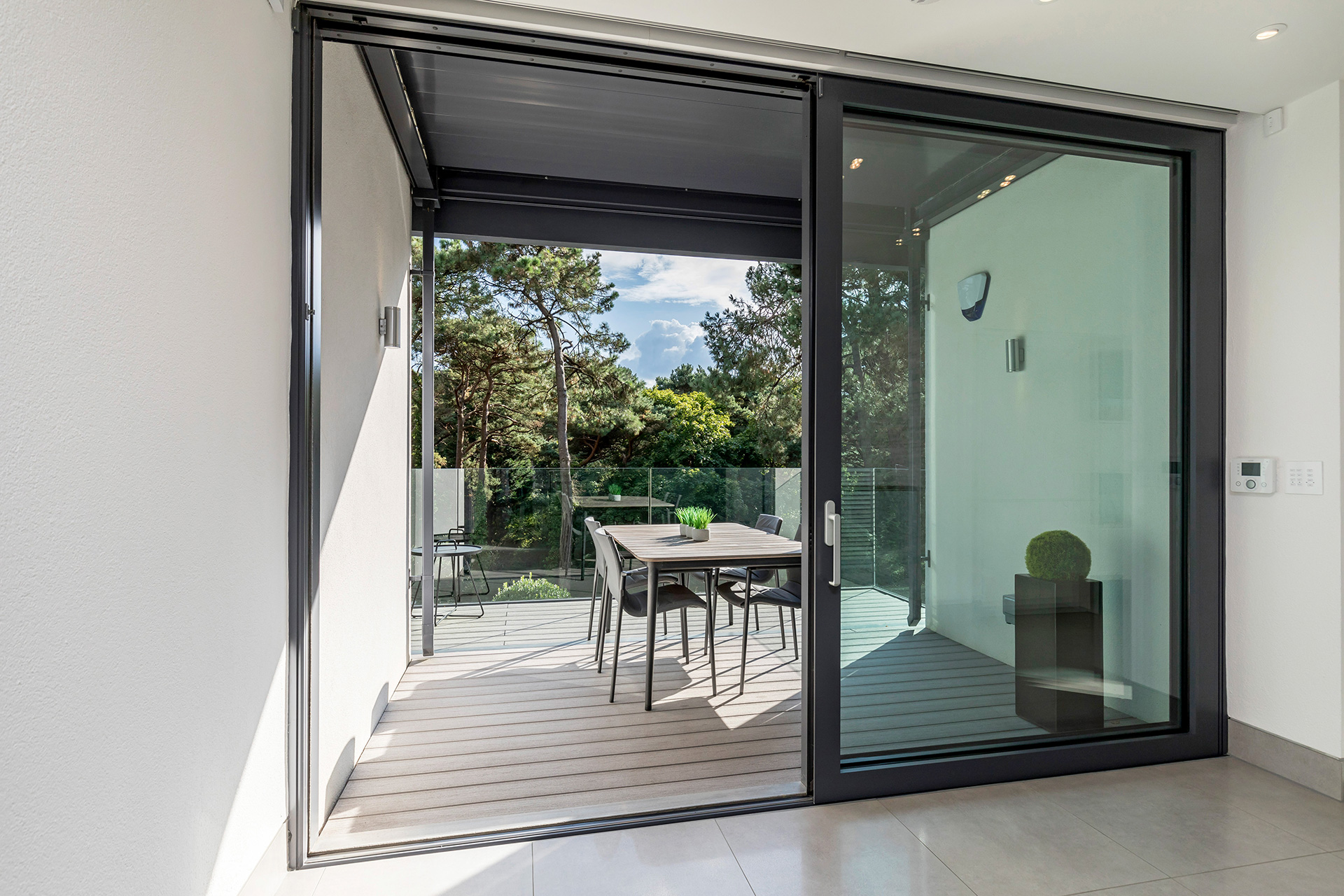 Balcony with table and chairs onlooking tree view