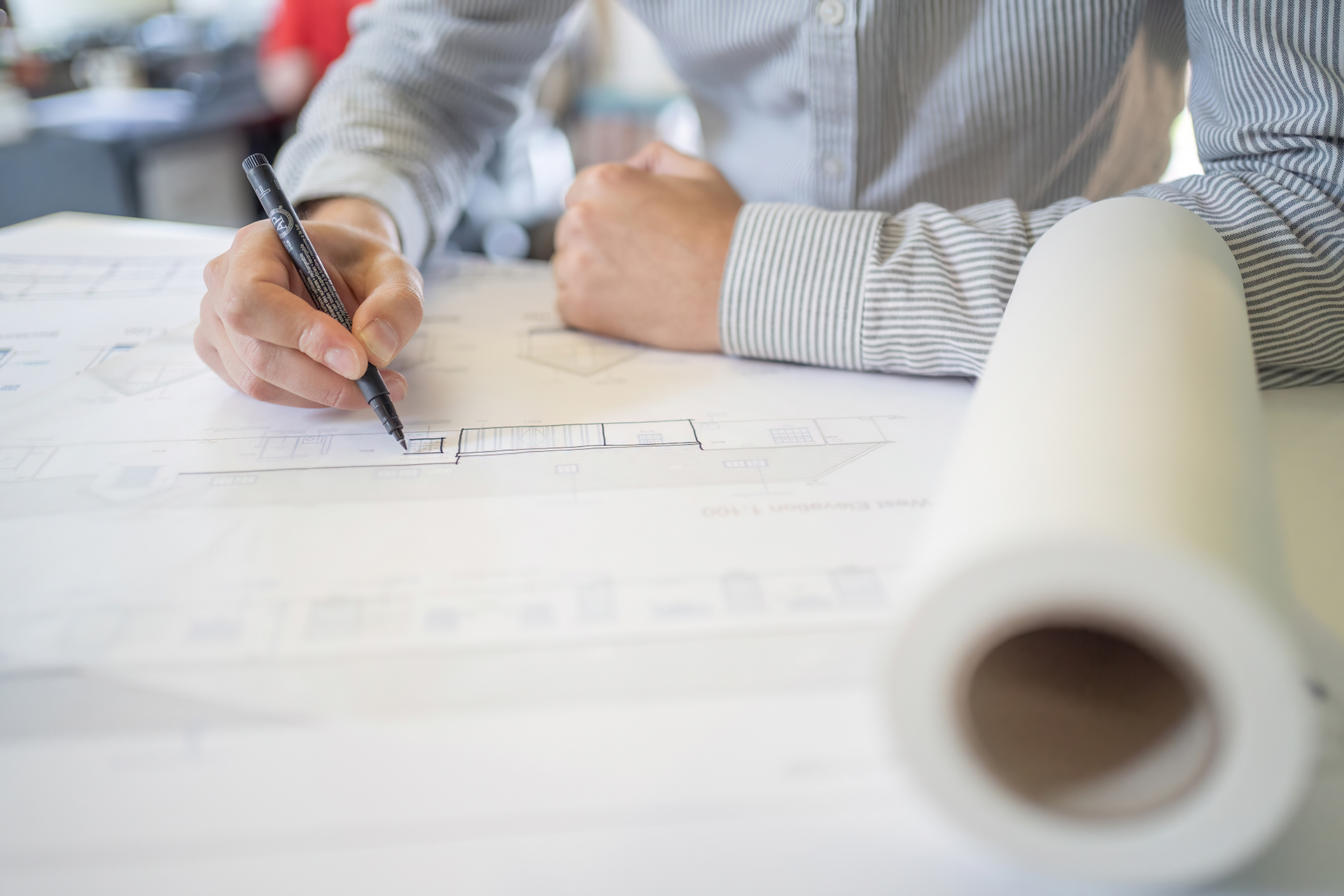 Person working on a sketch at table