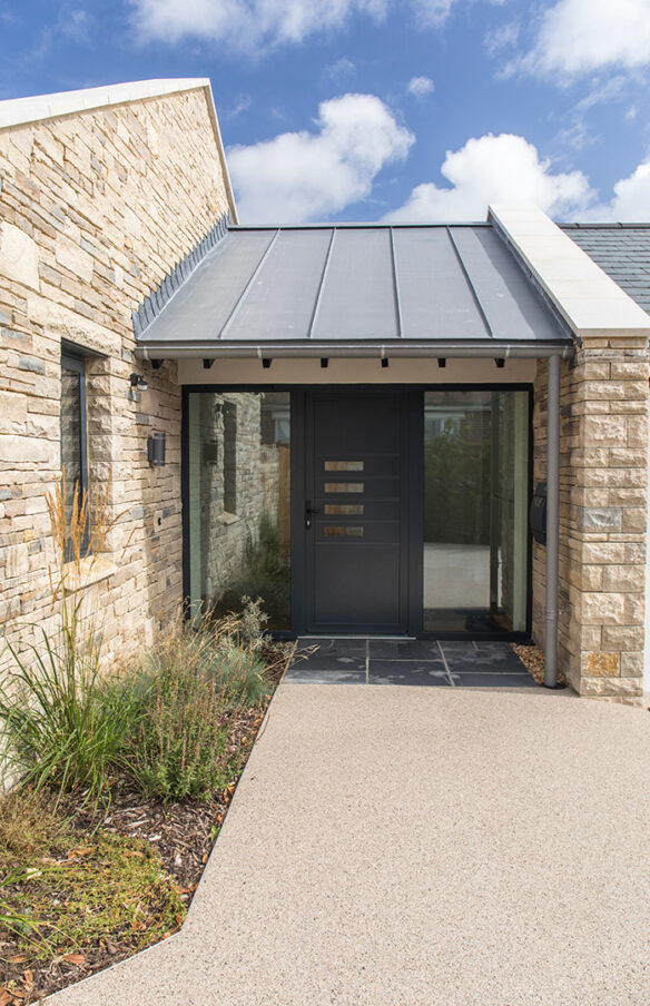 Entrance porch showcasing stone walls and zinc roof