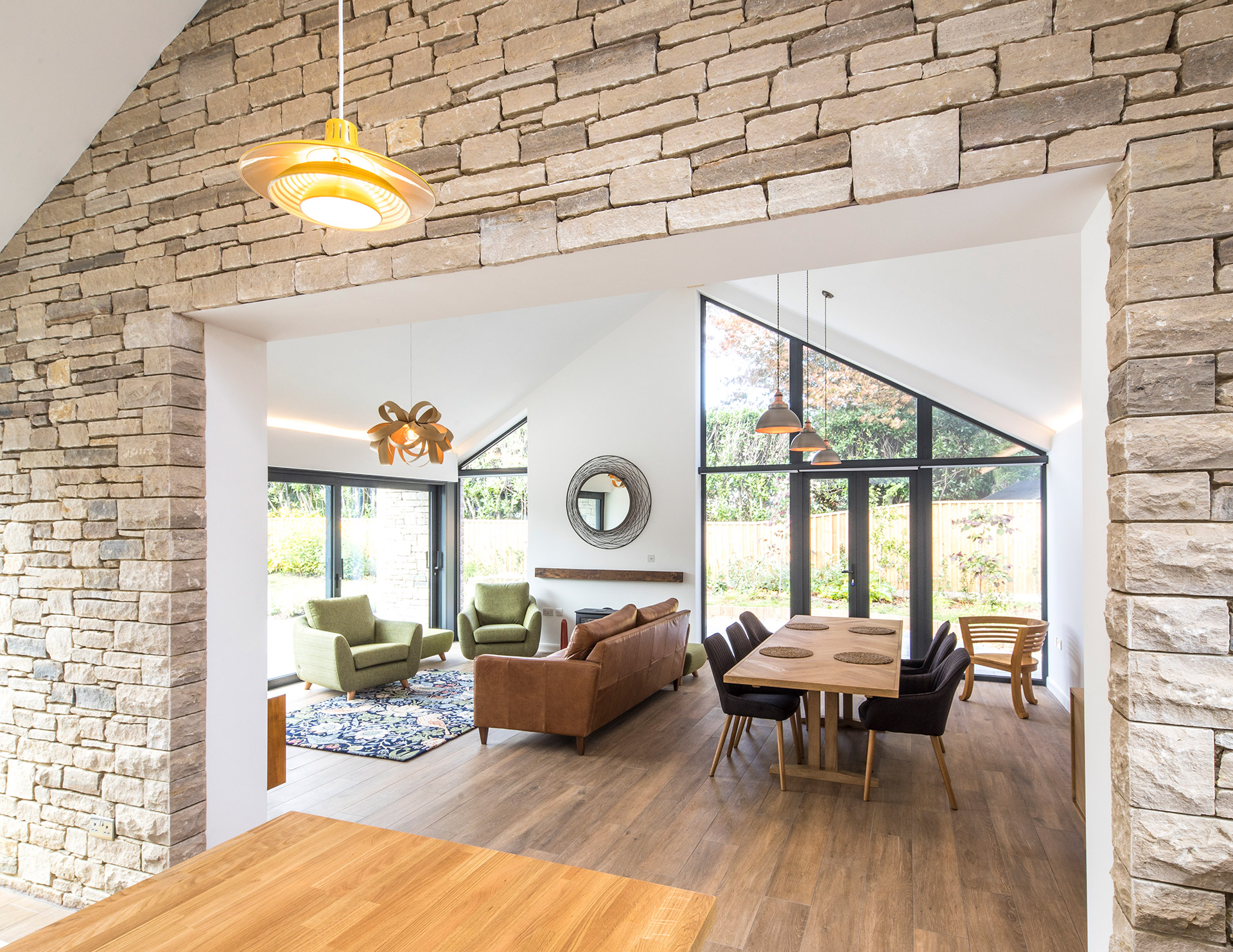 open plan living and dining space with exposed purbeck stone walls