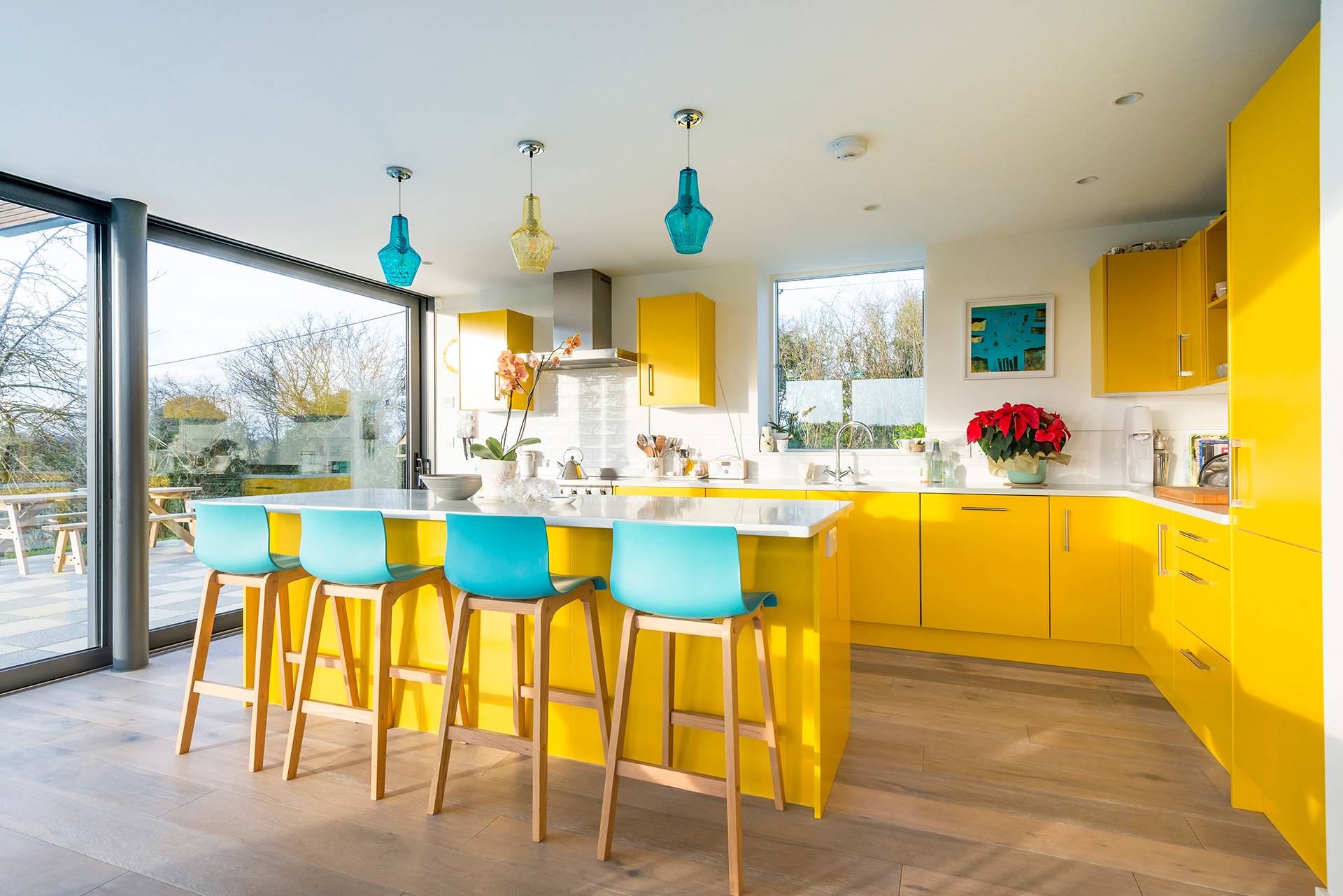 bright yellow modern kitchen with blue chairs at breakfast bar