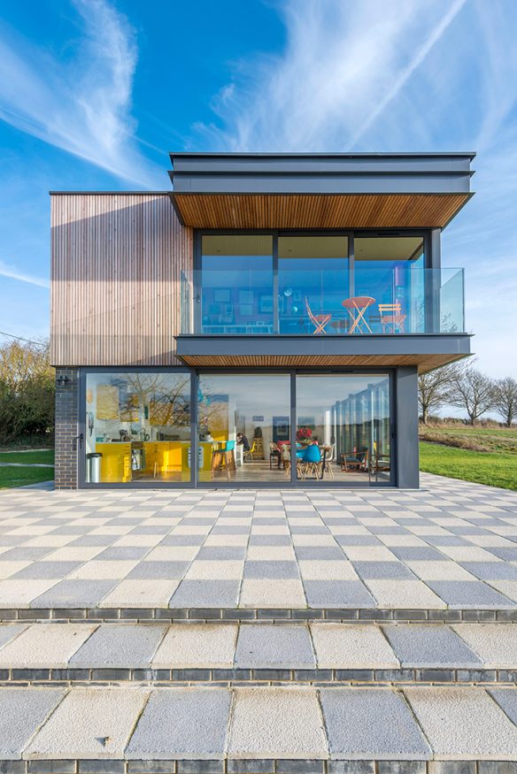 House with cantilever balcony over checkerboard patio