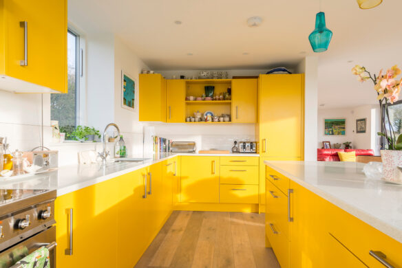 Yellow kitchen with blue light fitting and timber floor
