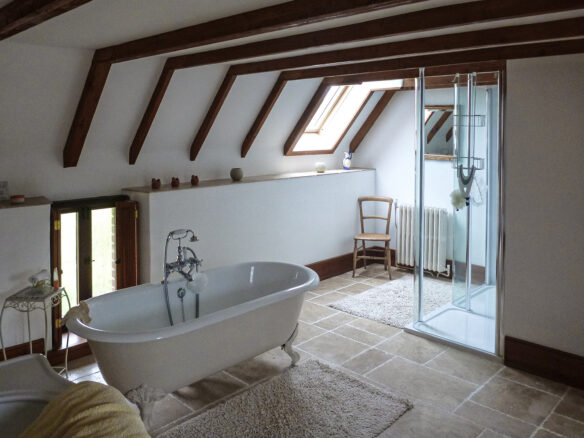 new bathroom with freestanding bath, stone flooring and beams
