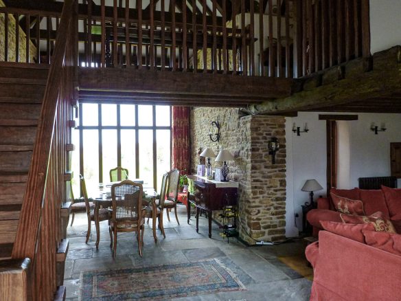 dining area with balcony above and large window