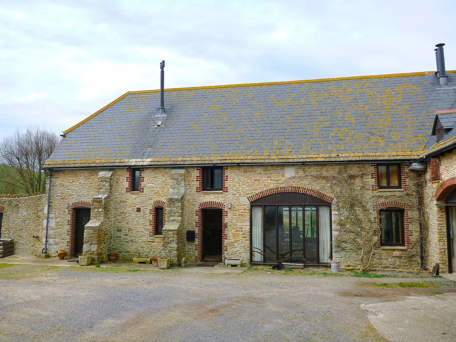Restored stone barn with slate roof and large ground floor window