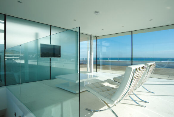 TV and glass balustrade, interior of building with stunning views of sandbanks
