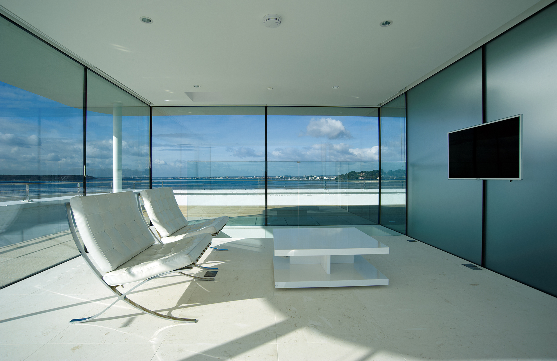 stunning contemporary interior and chairs in glass rooftop pavilion