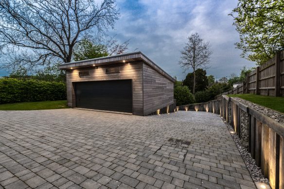 detached timber garage with lights at dusk