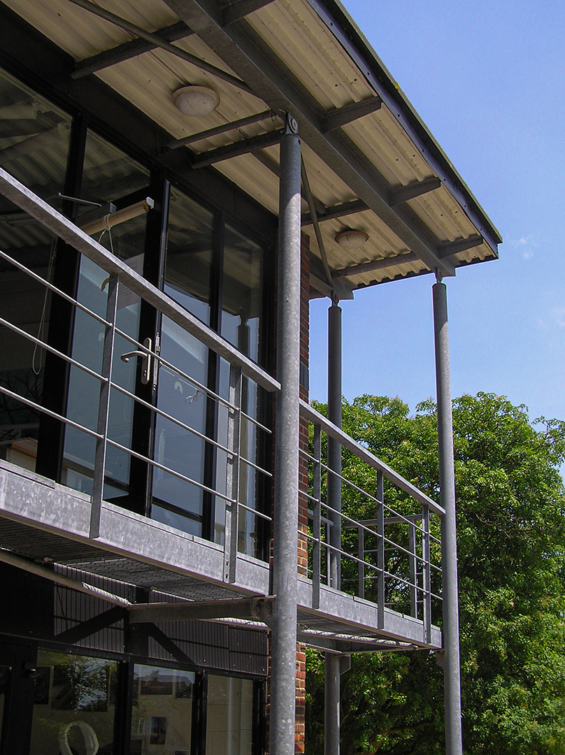 Galvanised steel balcony supporting an overhanging roof to a school