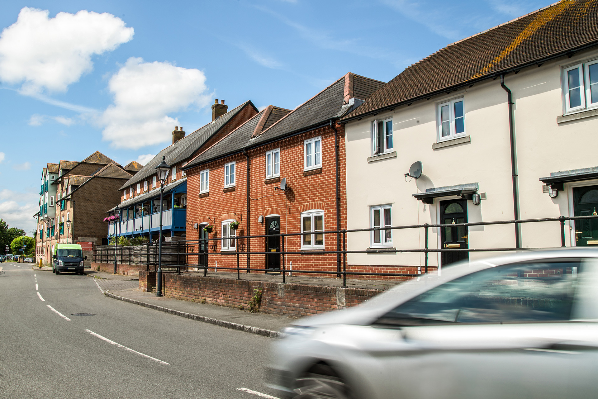 street view of attached red brick housing with black front doors