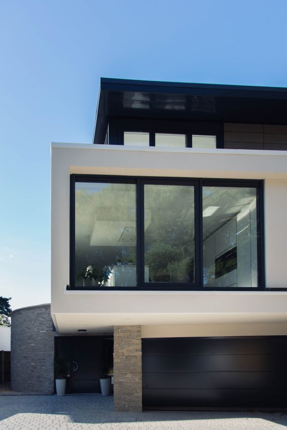 driveway approach view of contemporary building with large windows