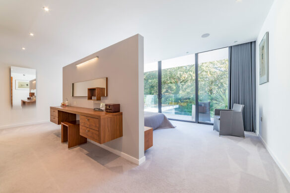 interior of master bedroom with large glass sliding doors onto balcony and internal privacy wall