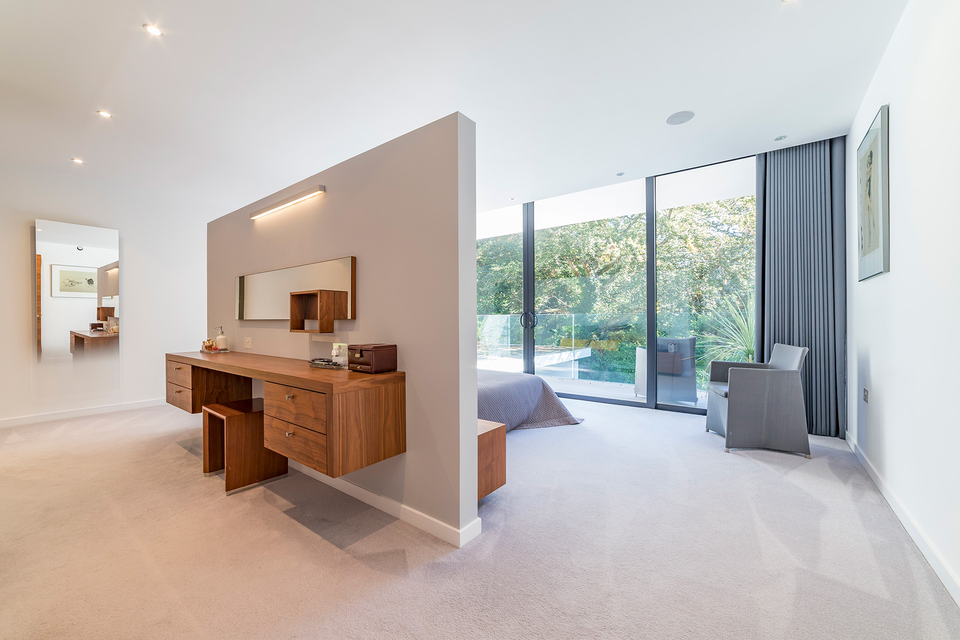 interior of master bedroom with large glass sliding doors onto balcony and internal privacy wall