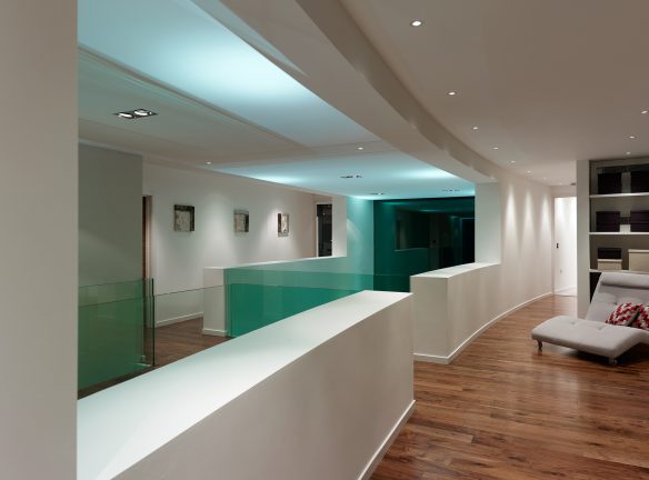 first floor hallway with impressive curved wall and glass railing