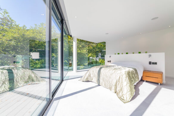 modern interior of master bedroom with sliding glass doors onto balcony