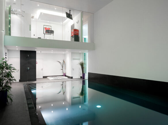 indoor swimming pool and jacuzzi with gym above