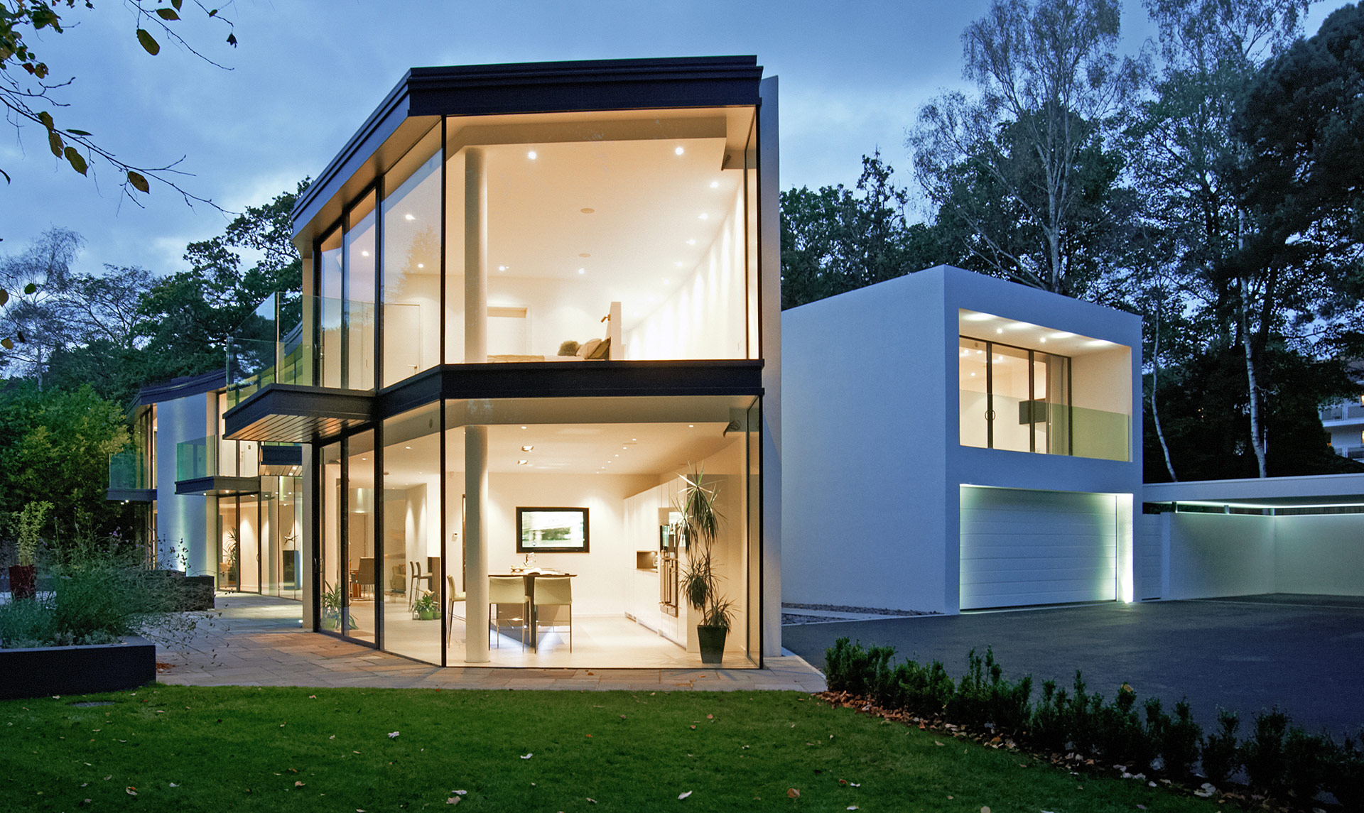 Beautiful modern glass house lit up at dusk