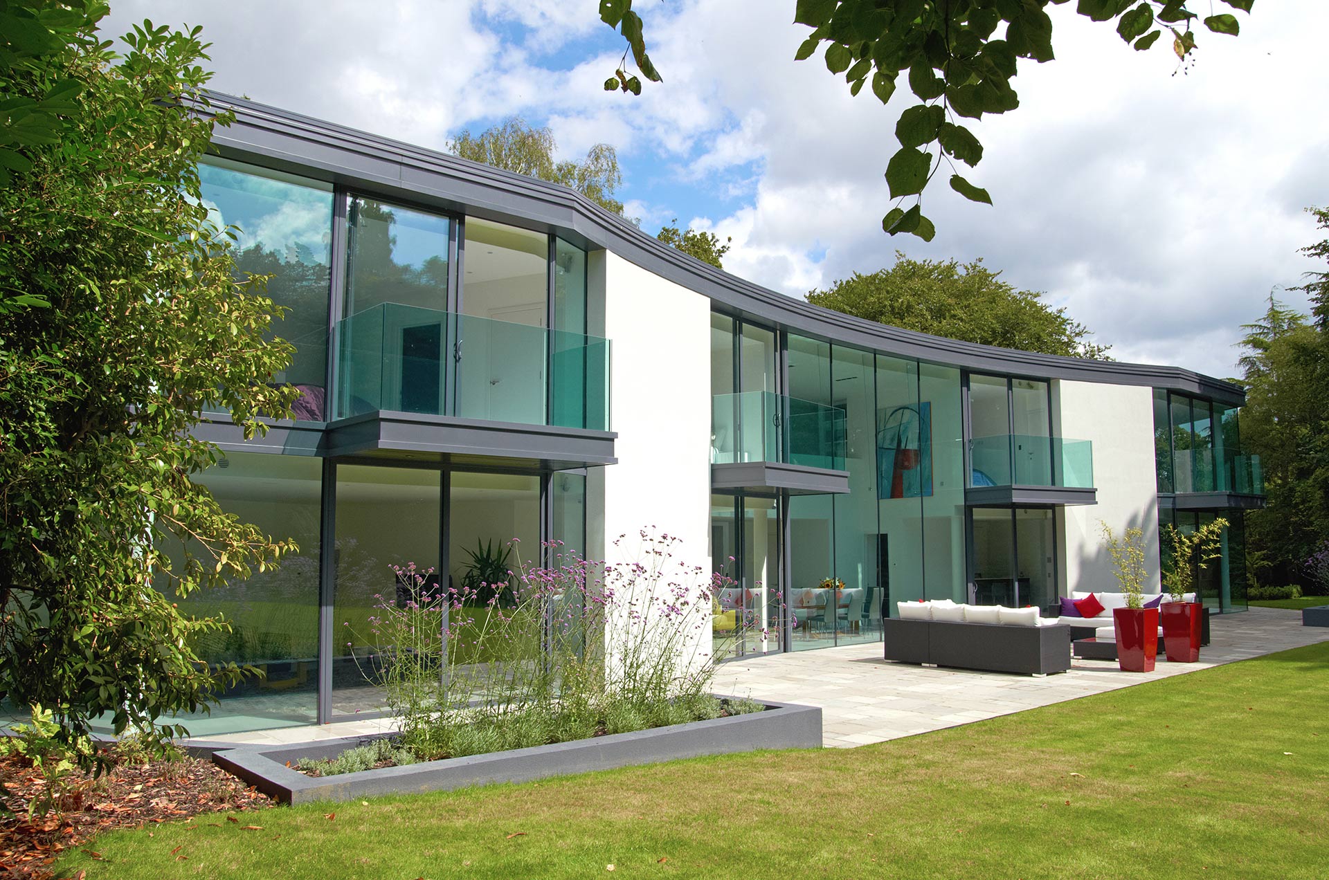 Curved rear of large house with big floor to ceiling windows