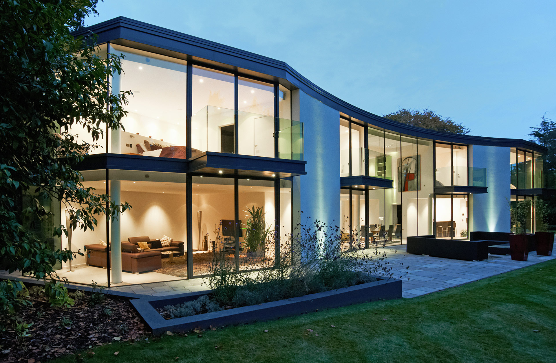 curved glazed house with lights on at night