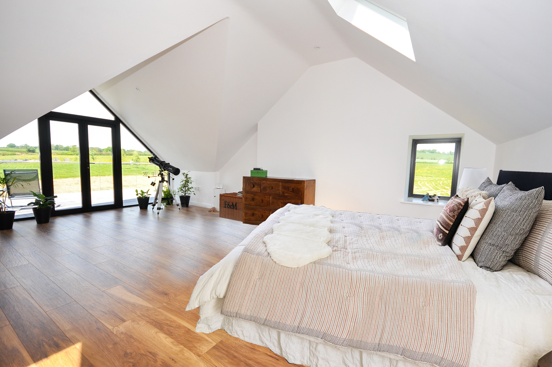 Bedroom with vaulted ceiling and feature window with patio doors