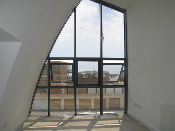 interior of building with large windows and curved roof