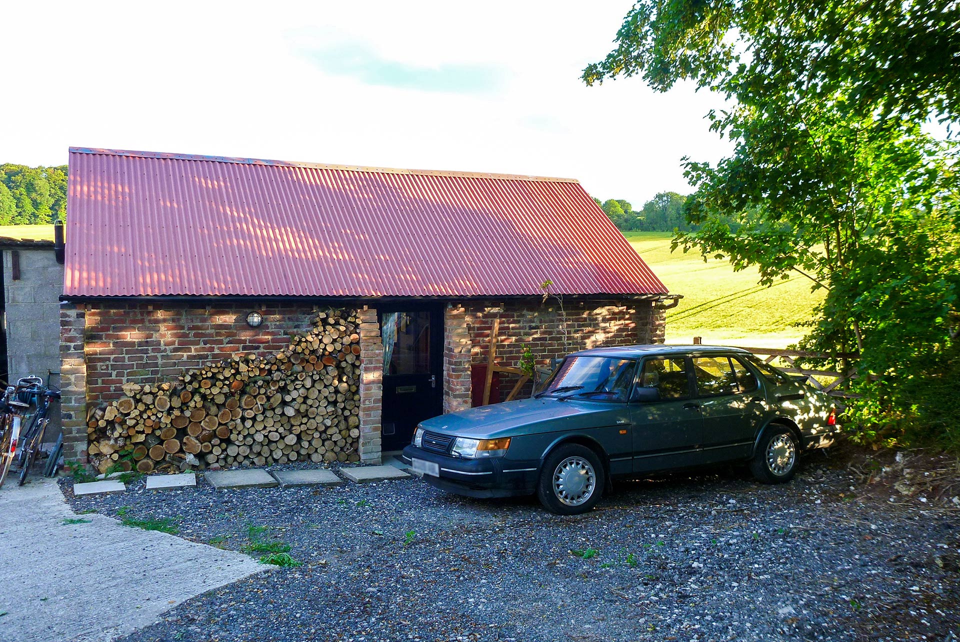 side of barn with log pile wall