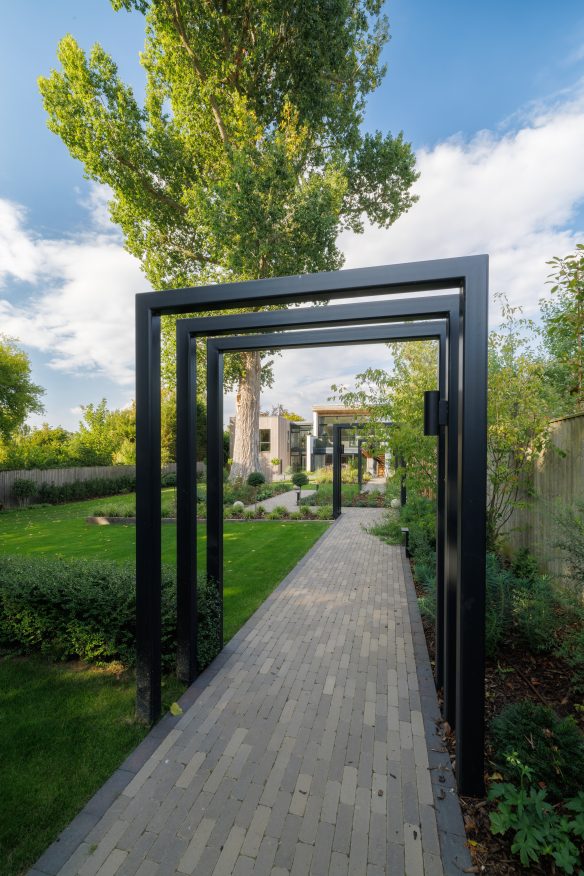 rear view of house from garden with modern decorative features and pathway to the house