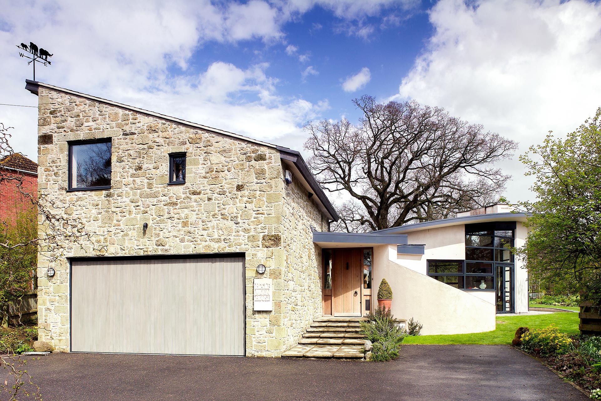 approach view of contemporary house with sloping ceilings, curved walls and garage