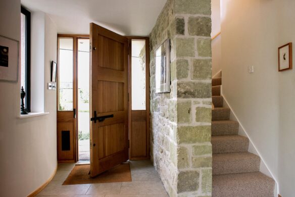 interior entrance view with dog-legged carpeted staircase and exposed walls