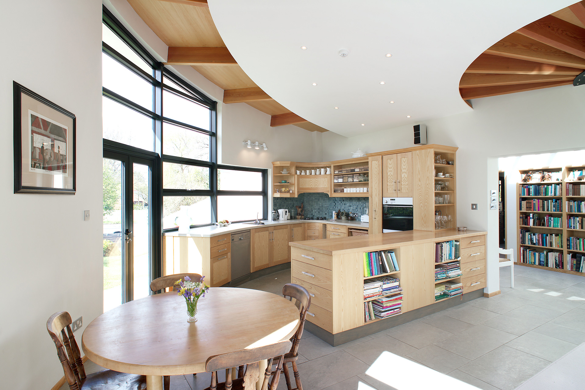 open plan kitchen and living space with curved wall and exposed beams