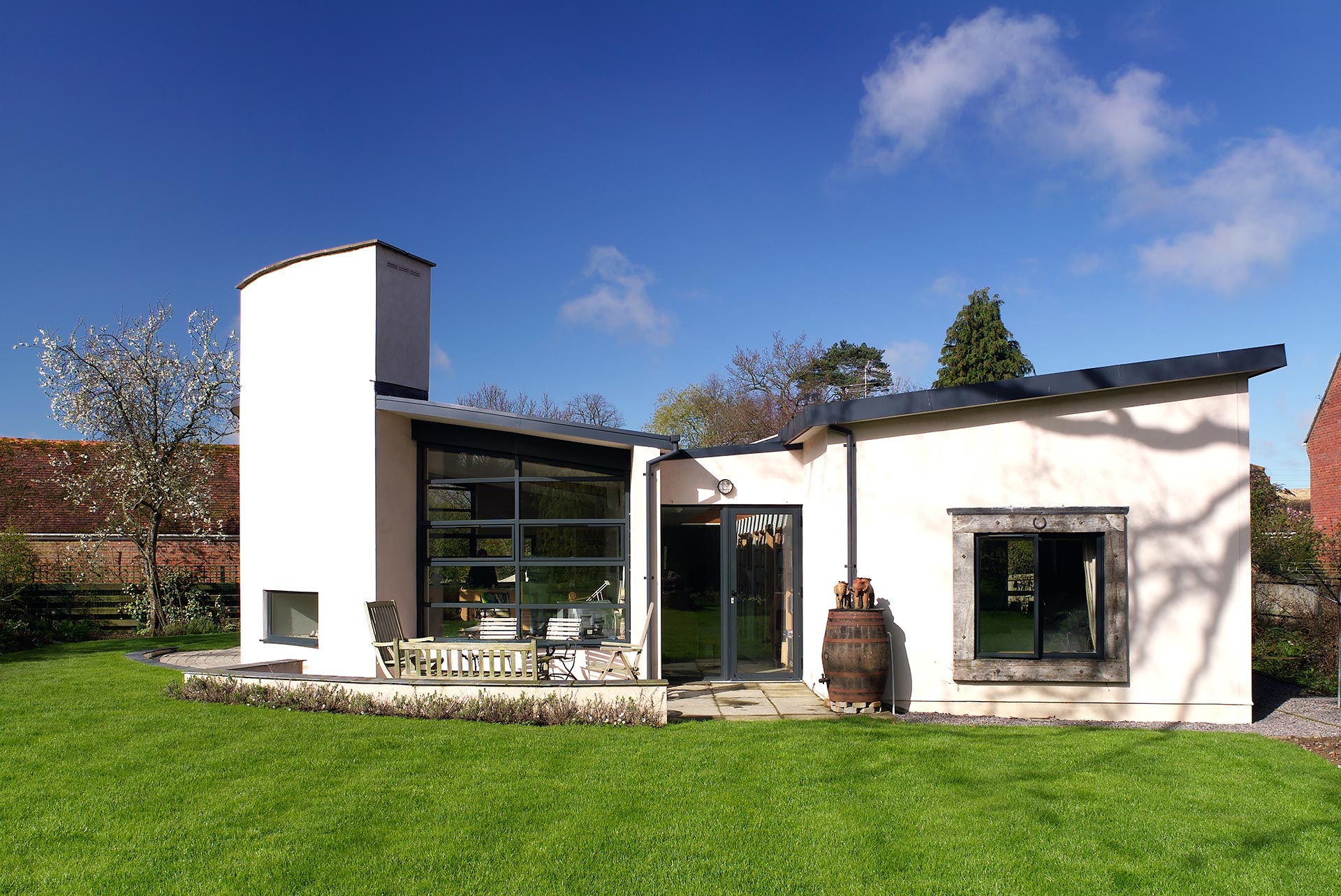 rear view of contemporary house with curved white walls and sloping roof in the day