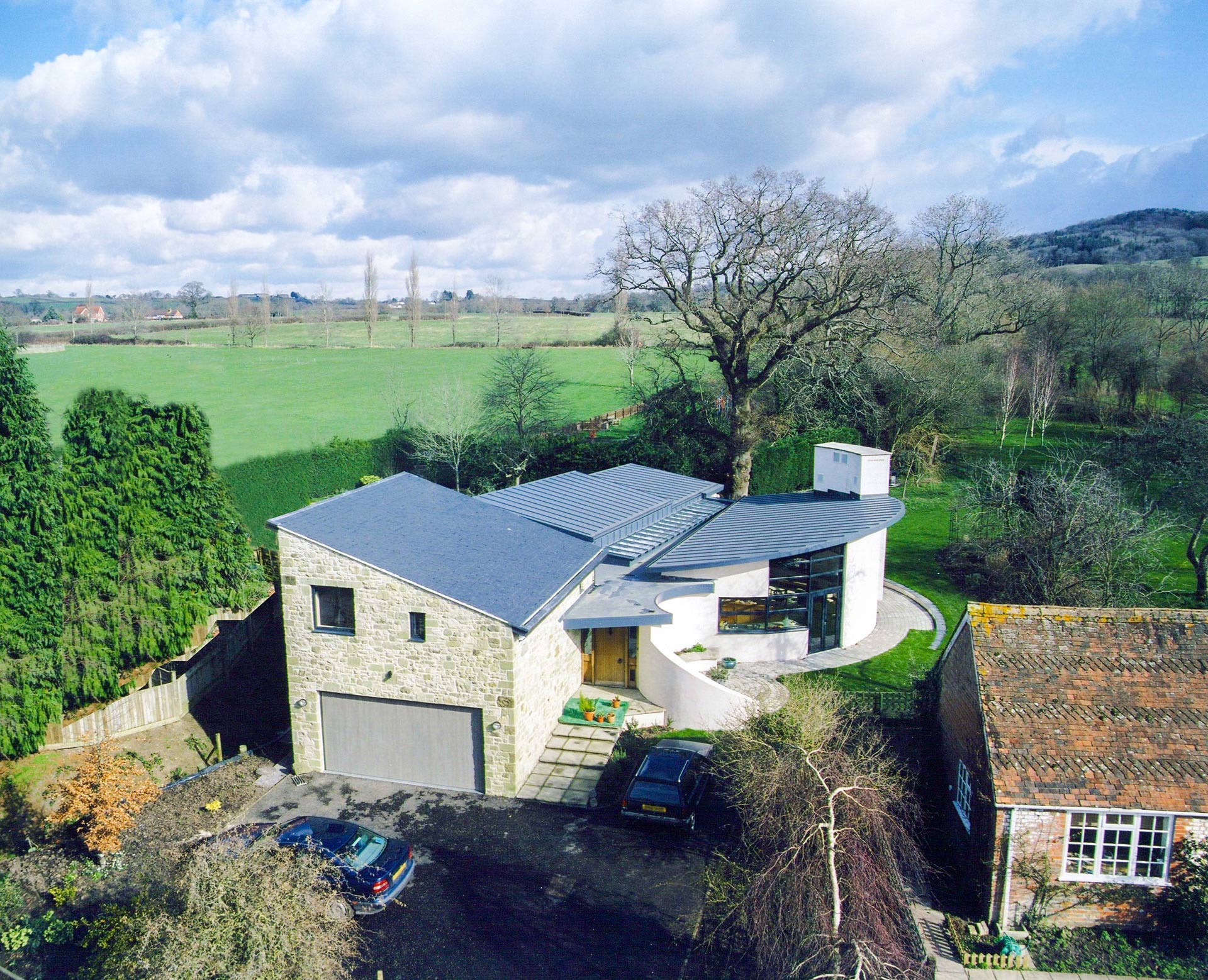 aerial view of contemporary house with curved walls and sloping roof