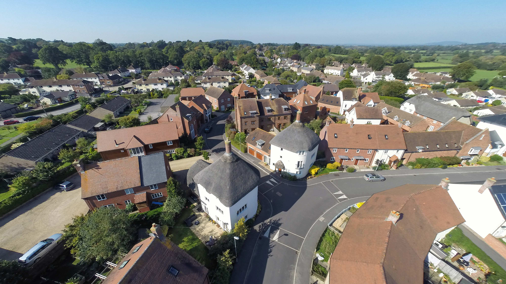 street view of shillingstone with red brick houses and thatched white corner houses