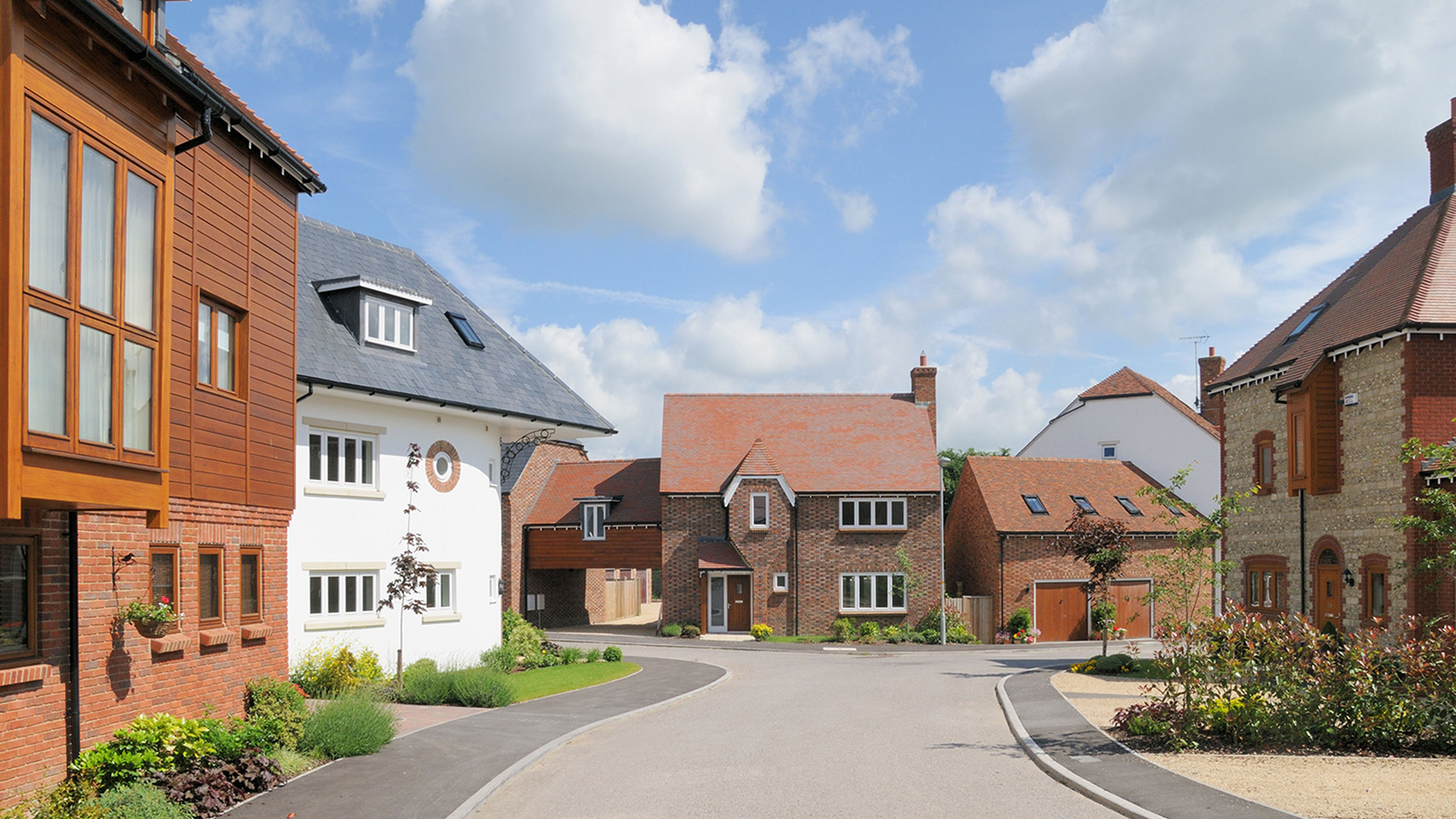 street view of red brick house and white corner house