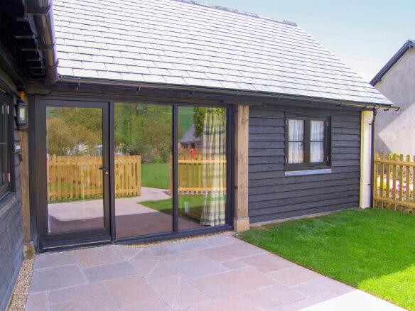 rear view of barn conversion with black timber cladding and large windows