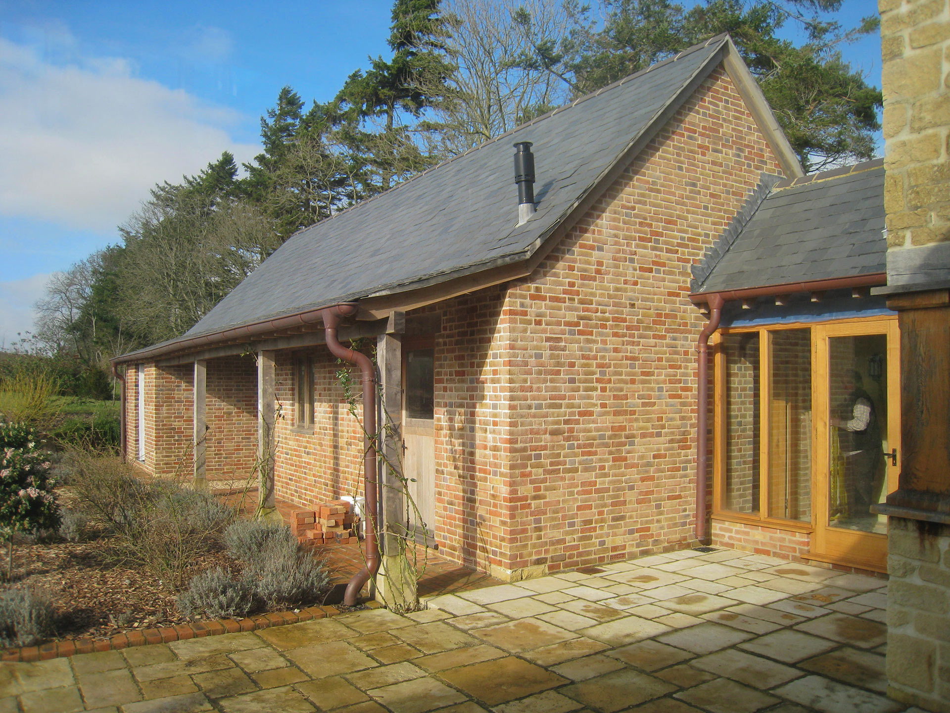 side view of red brick barn conversion with glass entrance