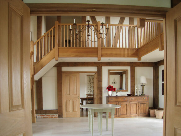 neutral toned entrance area with mezzanine and exposed beams in walls