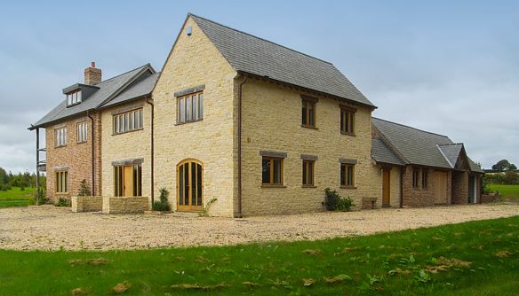 side and front view of stone and red brick house with gable end