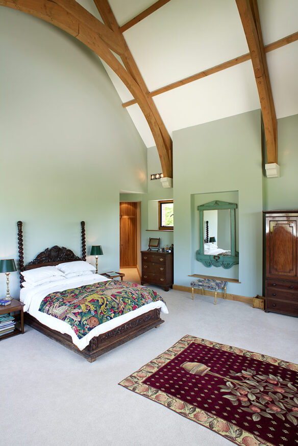interior double height bedroom with green walls and exposed wooden beams