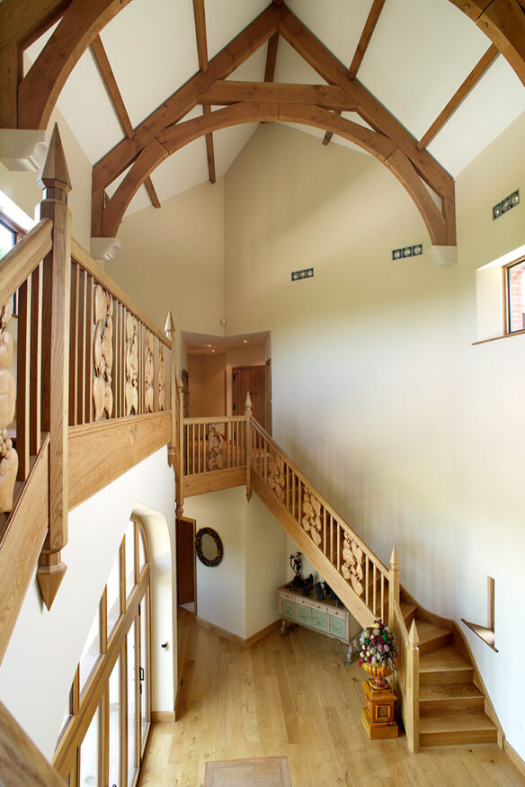 grand entrance hall with large dog legged staircase and exposed wooden beams